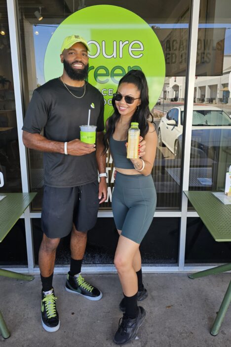 Two people standing in front of Pure Green Juice Bar