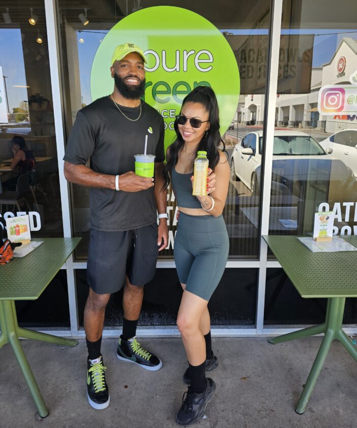 Two people standing in front of Pure Green Juice Bar